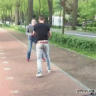 Girl on bike runs into guys fighting 