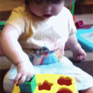 Girl figures out how to get the shapes in the box