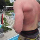 Guy dives in swimming pool holding a ball